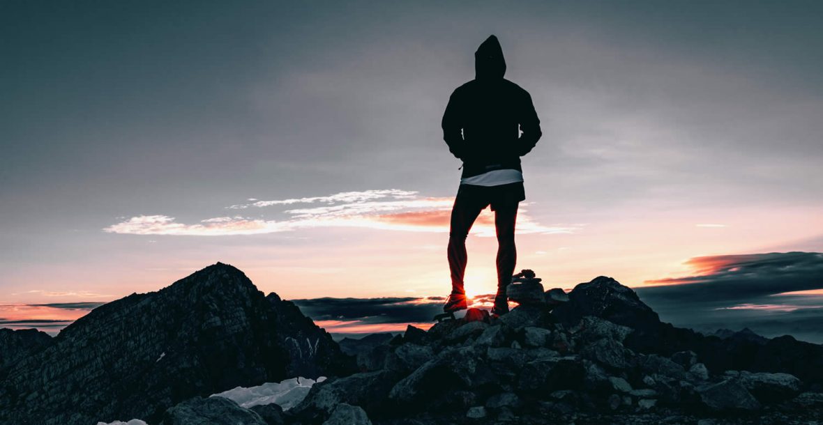 Walker standing on a mountain ridge